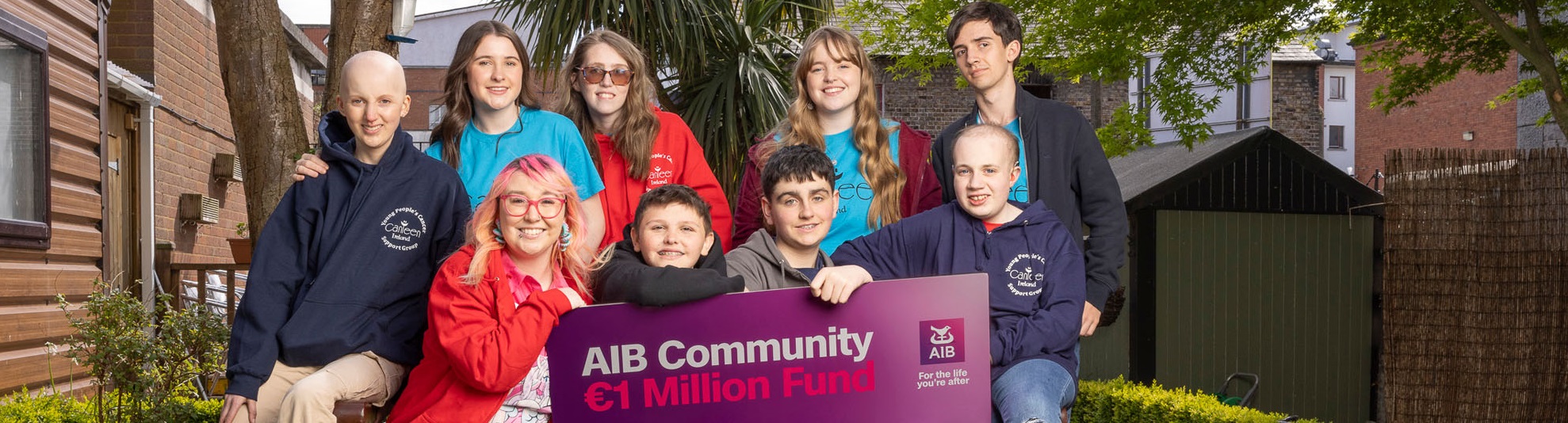 Group of boys and girls with banner saying AIB Community €1 Million Fund Charities!