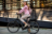Woman posing on her bike outside an apartment building.