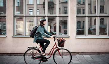 A woman riding her bike past a building in a city