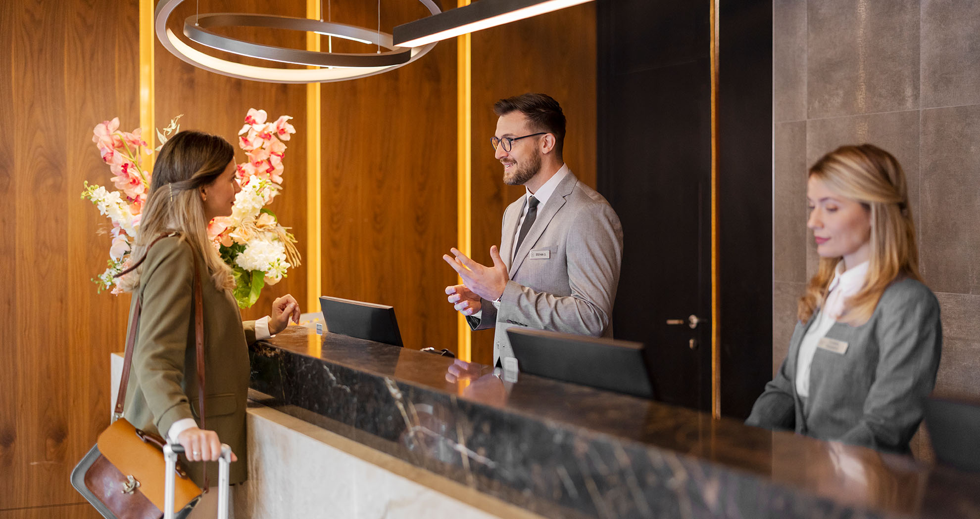 Young woman checking in at a Hotel reception desk.