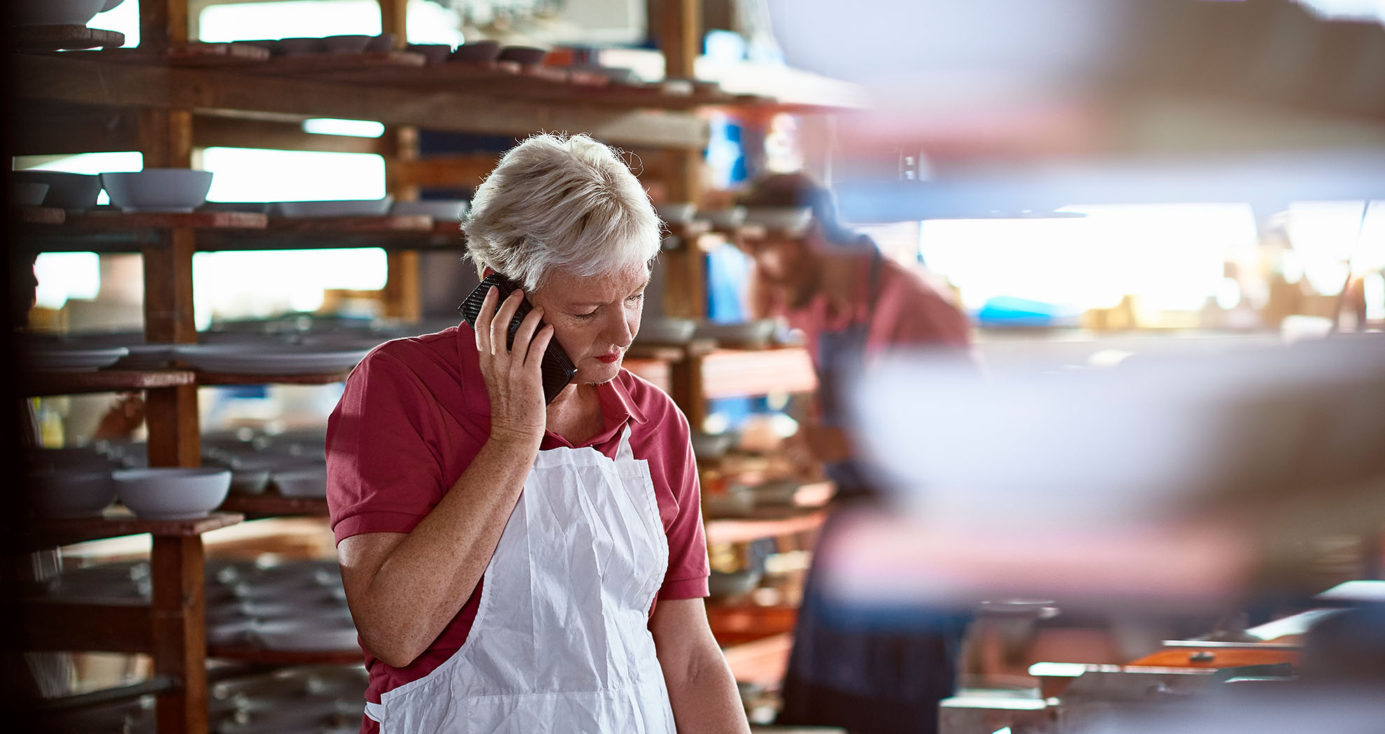  Older Lady on the phone in a warehouse, making an action plan