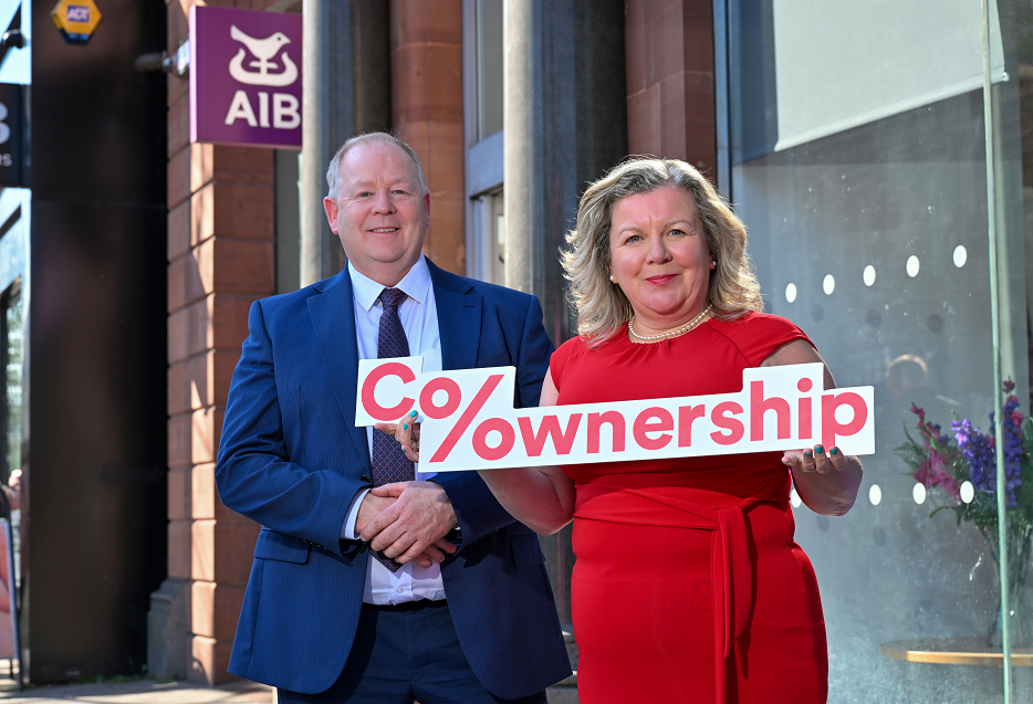 two people holding co-ownership sign